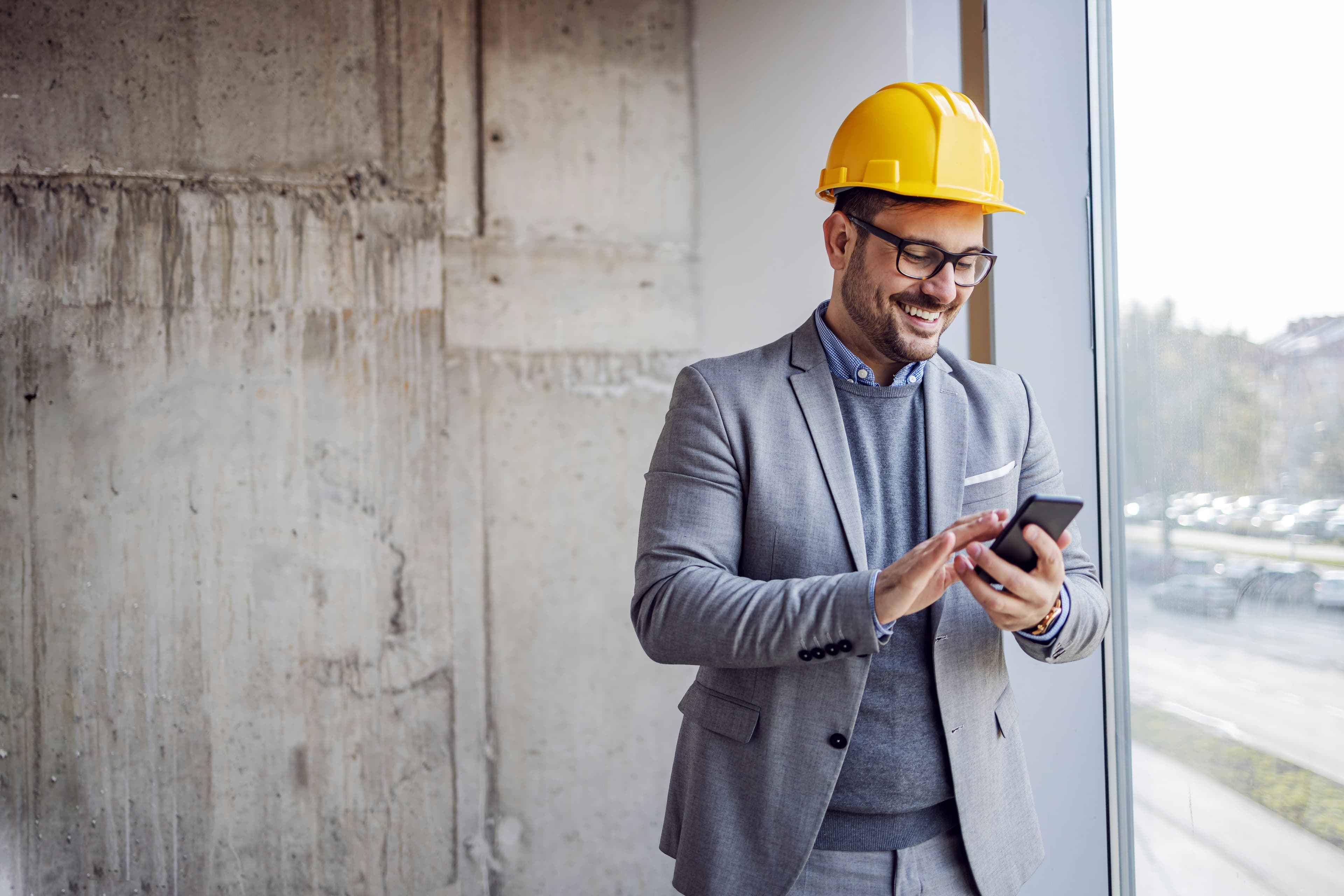 Construction professional reviewing compliance on phone